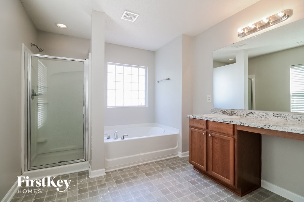 a bathroom with a tub and a sink and a shower