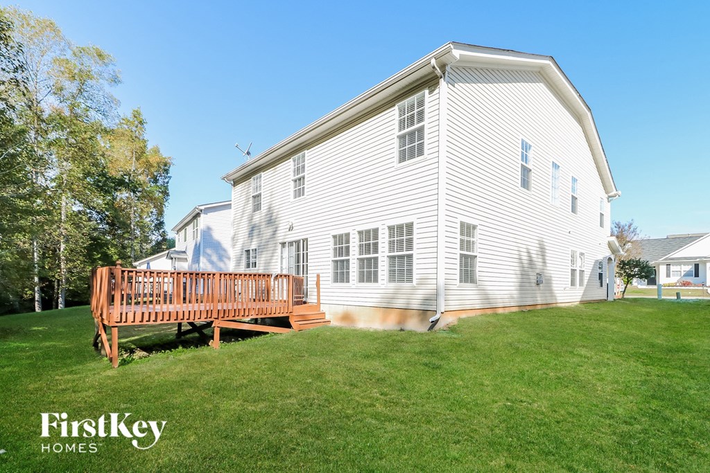 a white house with a wooden deck in front of it
