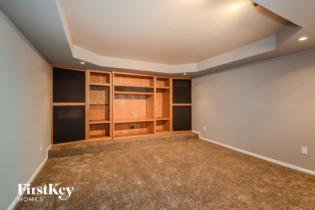 a bonus room with built in shelving and a carpeted floor