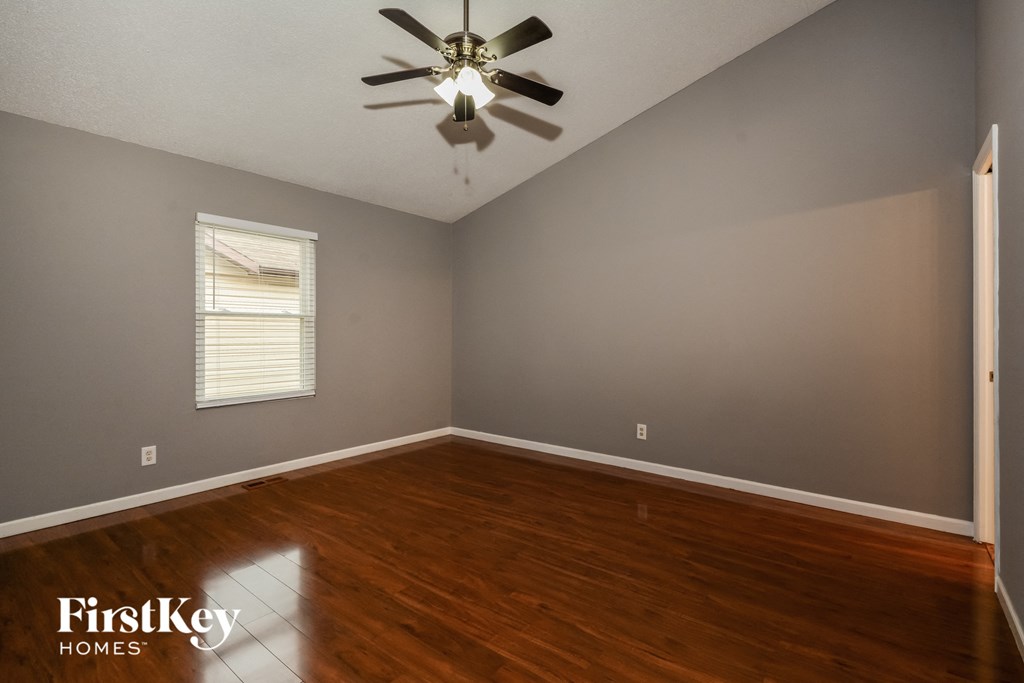 a bedroom with hardwood floors and a ceiling fan