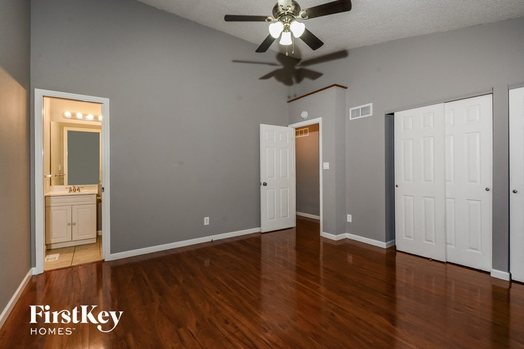 the living room of an empty house with wood floors and a ceiling fan