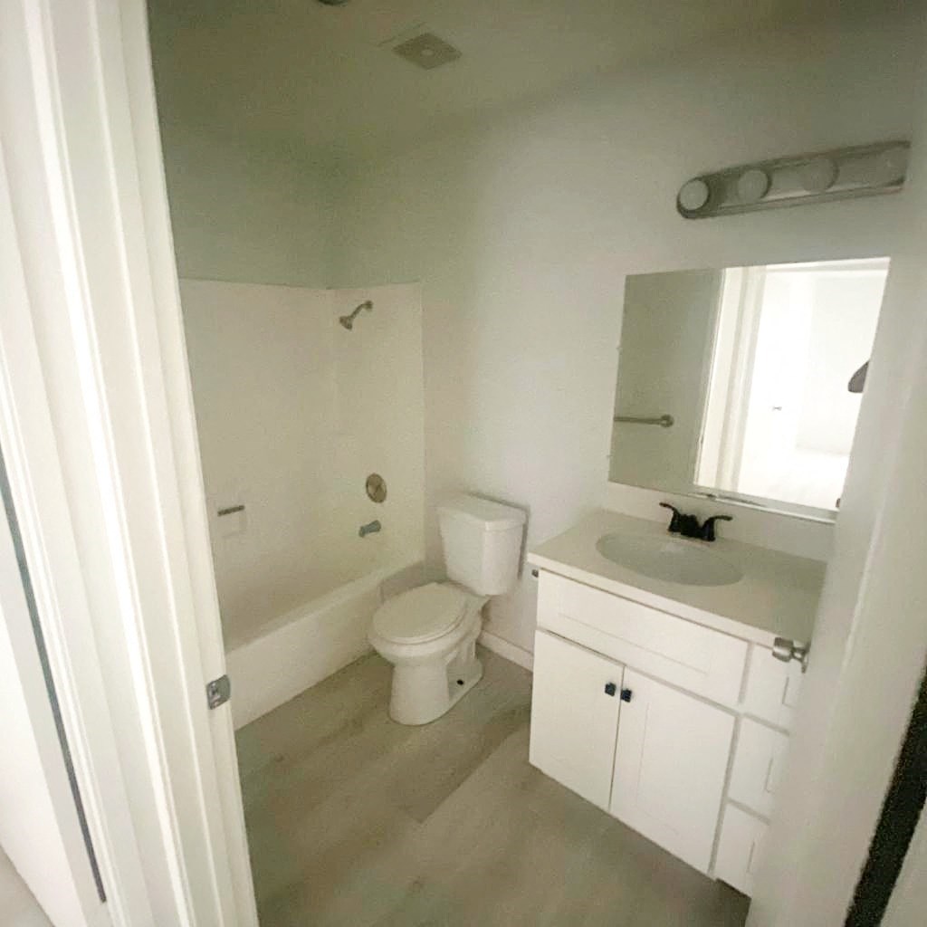 a white bathroom with a toilet and a sink