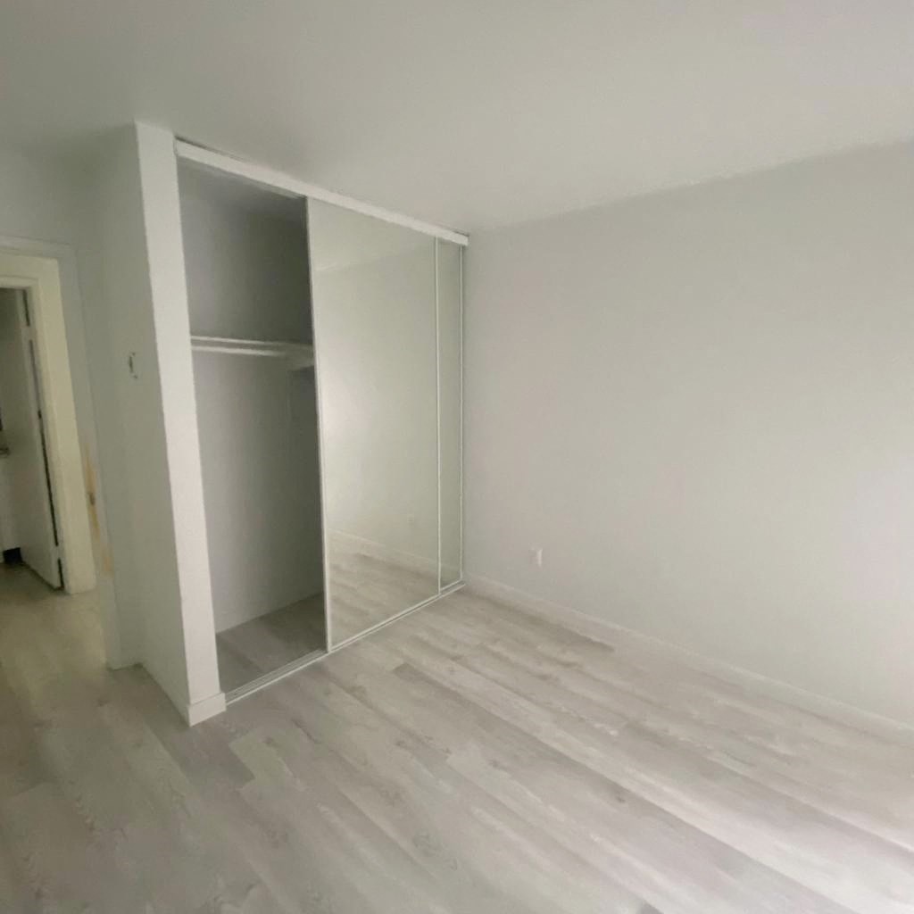 an empty room with white walls and a closet