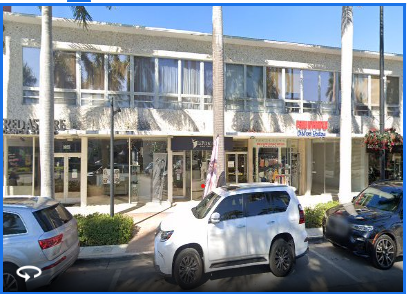 a white car parked in front of a building