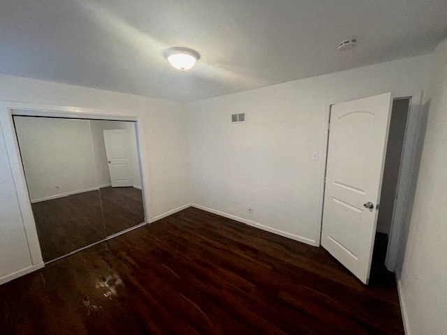 an empty room with a wooden floor and a white door