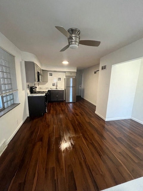 an empty living room and kitchen with wood floors