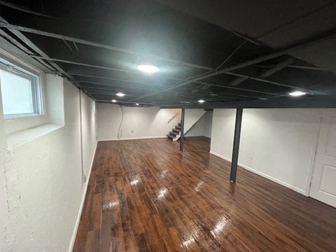 a living room with a wooden floor and white walls