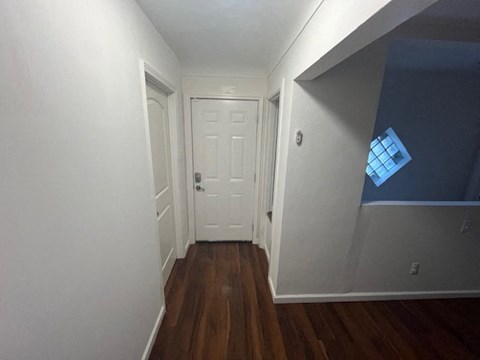 a hallway with a white door and a window