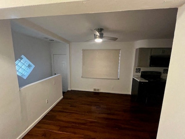 an empty living room with a wood floor and a ceiling fan
