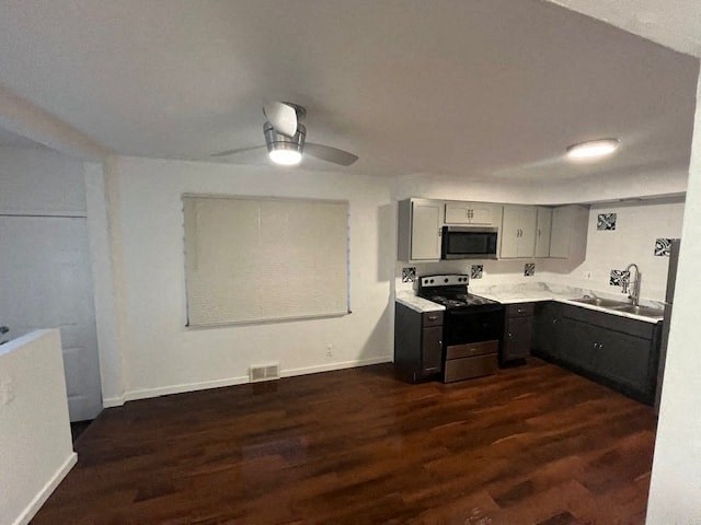 an empty kitchen with a wood floor and black appliances