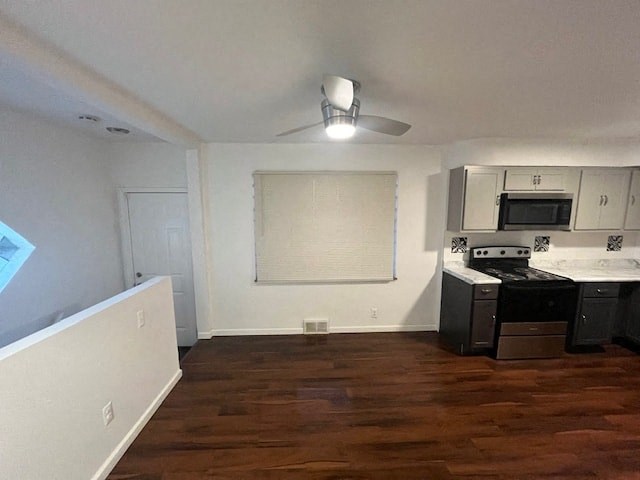 a kitchen with a stove and a ceiling fan