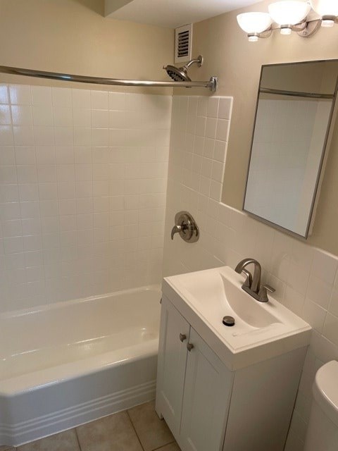 A white bathroom with a tub, sink, and mirror.