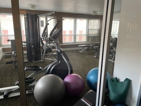 A gym with a variety of equipment including weights and exercise balls.