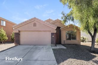 a single story home with a garage door and a tree