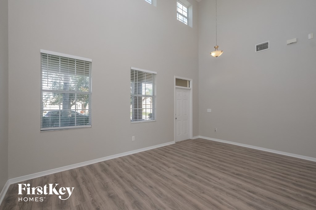 an empty living room with wood floors and a white door