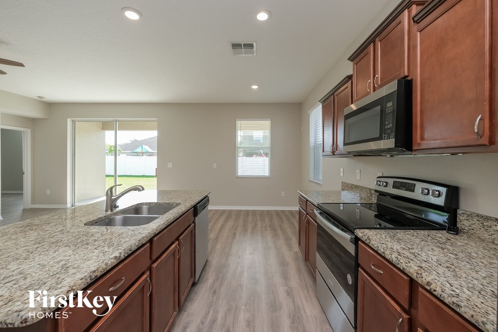 the kitchen has granite counter tops and stainless steel appliances