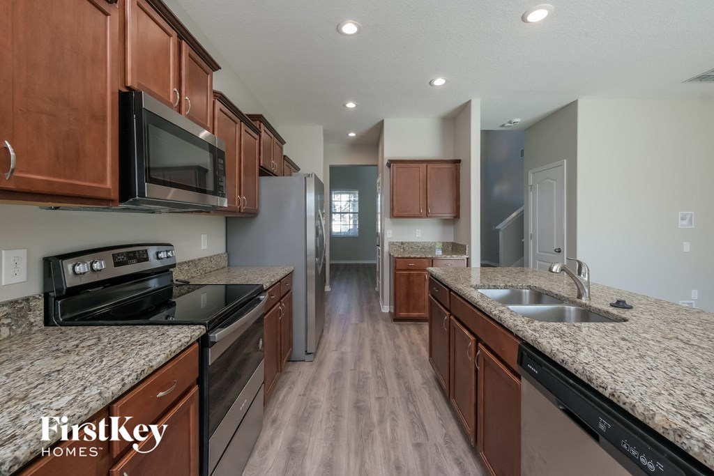 a kitchen with granite counter tops and wooden cabinets