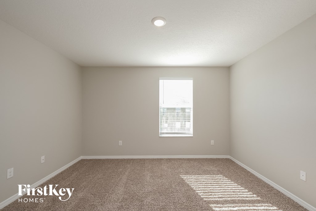 an empty room with carpet and a window
