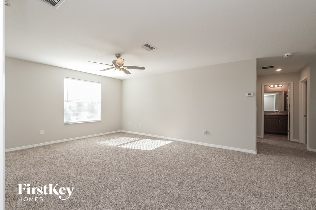 a living room with carpet and a ceiling fan