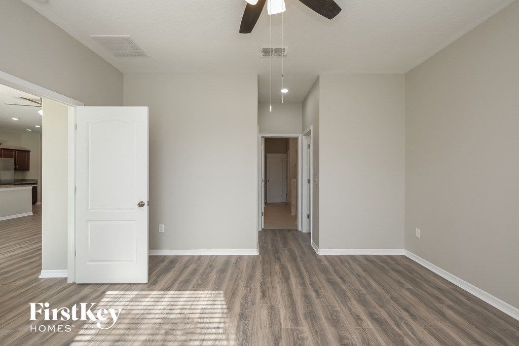 a renovated living room and hallway with wood flooring and a ceiling fan