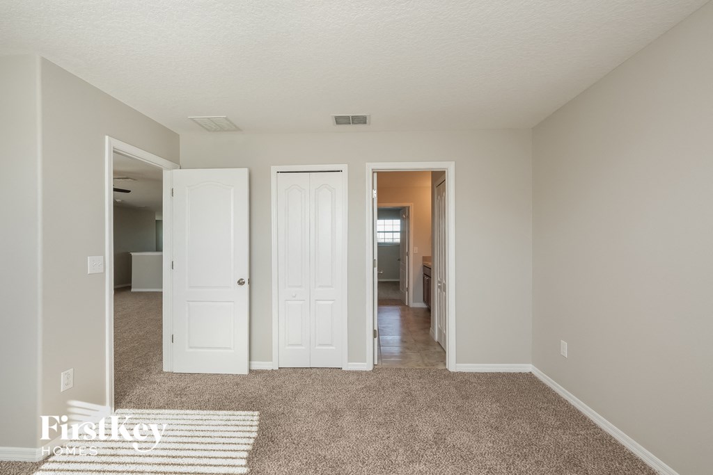 a living room with a carpeted floor and white doors