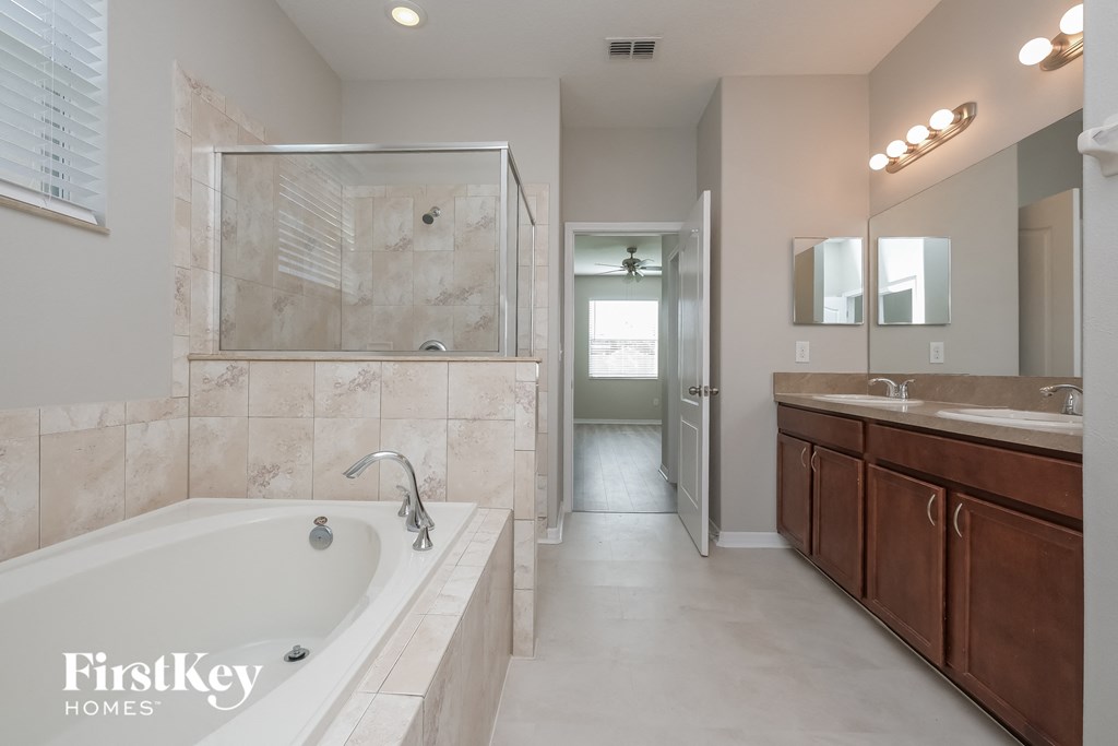a bathroom with a tub and a shower and a sink