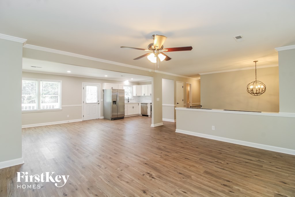 A spacious living room with wood flooring and a ceiling fan.