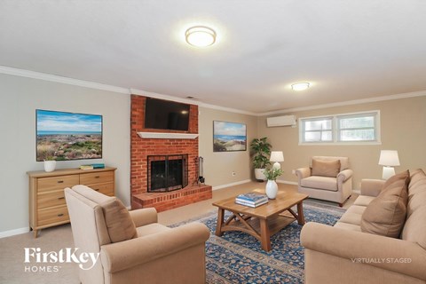 A living room with a fireplace and a painting on the wall.