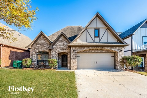 two story home with brick and stone exterior and a garage