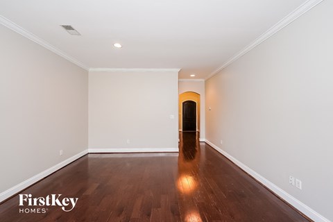 a empty living room with white walls and wooden floors