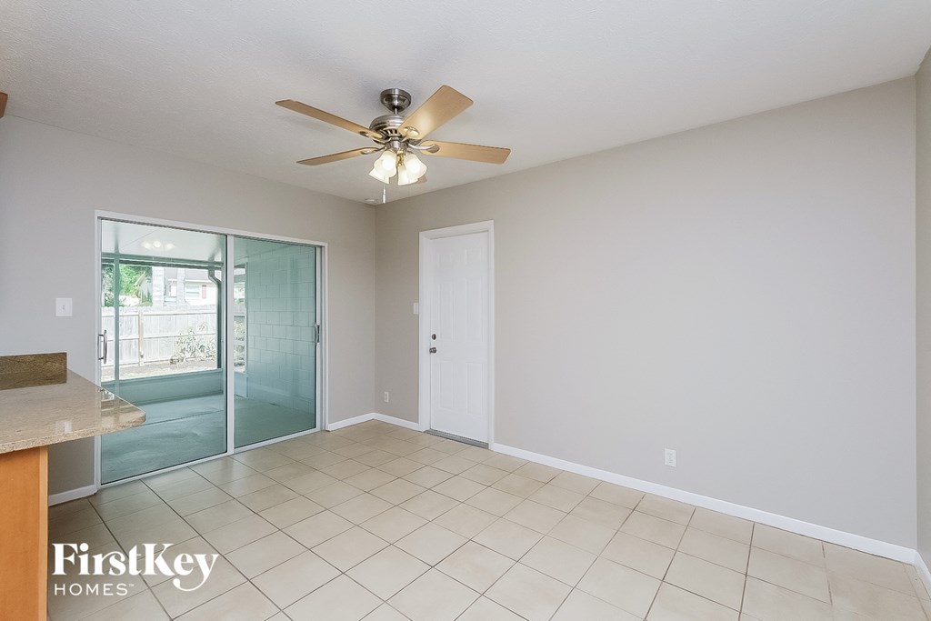 a living room with a ceiling fan and a sliding glass door