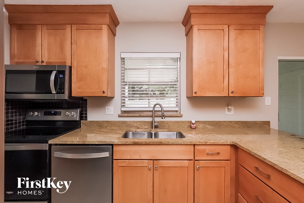 a kitchen with wooden cabinets and granite counter top and a sink