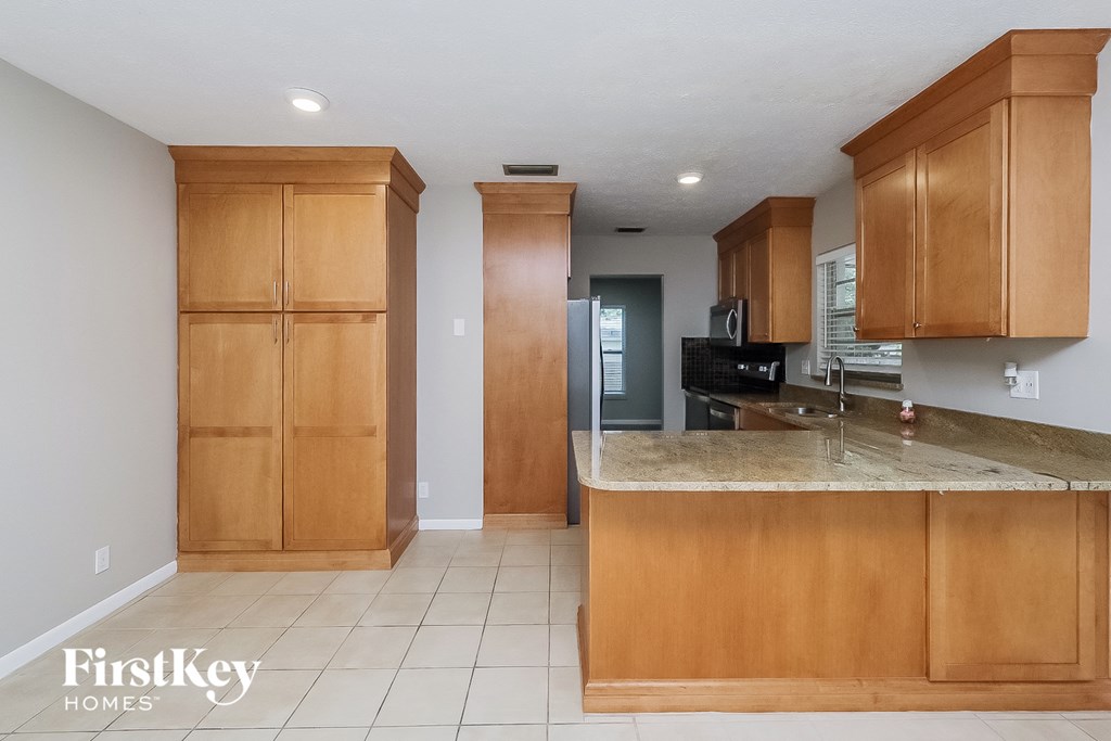 a kitchen with wooden cabinets and a marble counter top