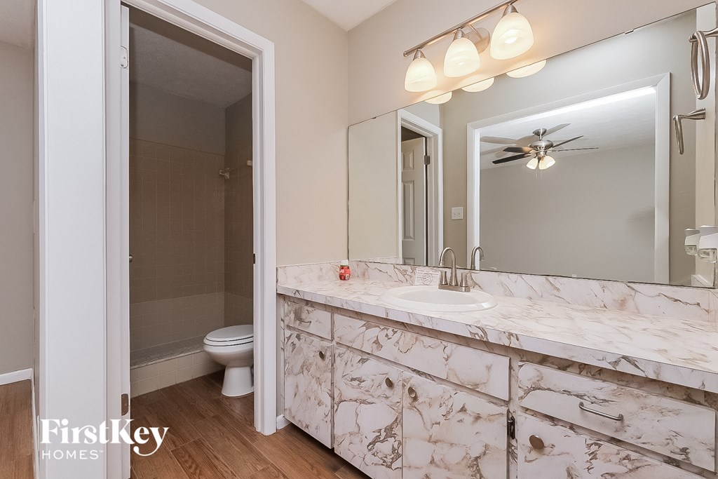 a bathroom with a large mirror and a sink and a toilet