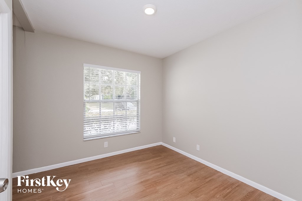 the living room of a home with wood floors and a window