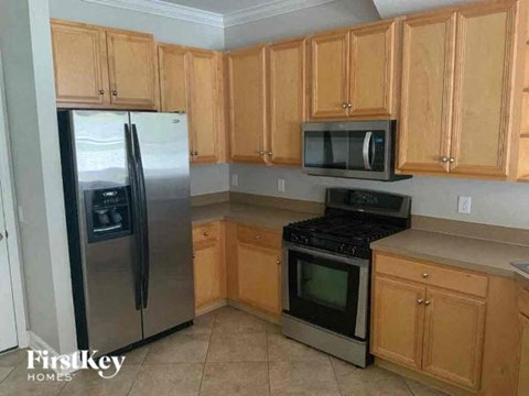 A kitchen with wooden cabinets and a stainless steel refrigerator.