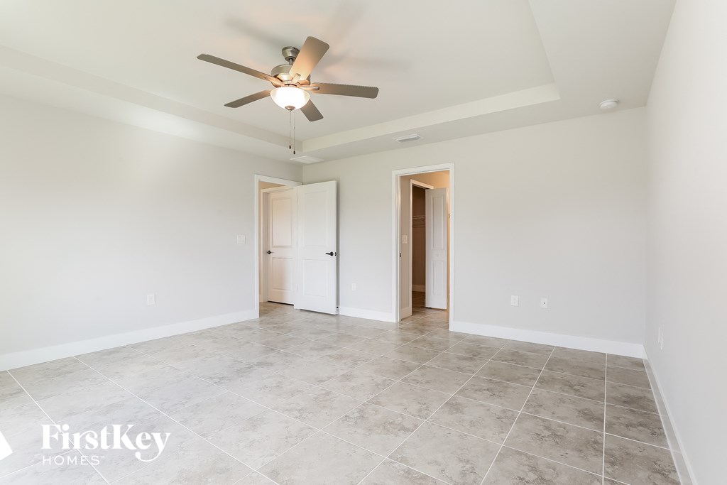 a clean and empty living room with a ceiling fan