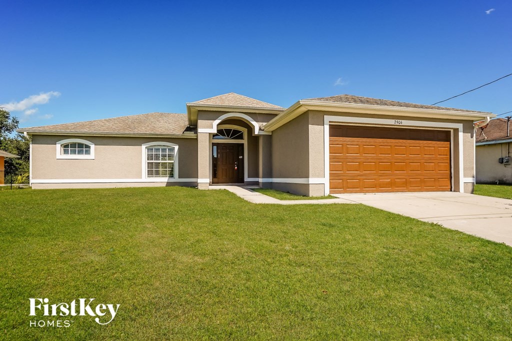a house with a garage door and a lawn