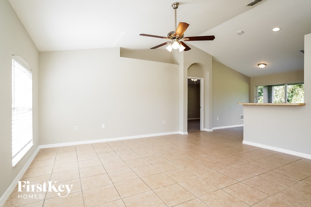 an empty kitchen and living room with a ceiling fan