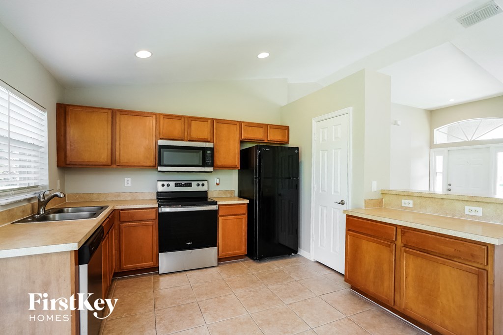 a kitchen with wooden cabinets and black appliances