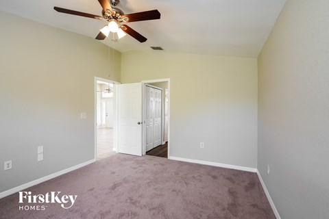 a living room with carpet and a ceiling fan