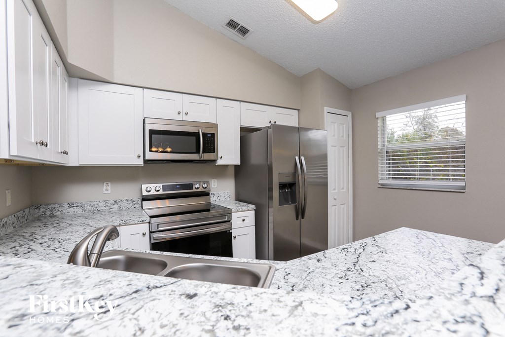 a kitchen with granite counter tops and stainless steel appliances