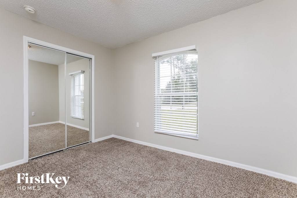 a bedroom with a mirror and a carpeted floor