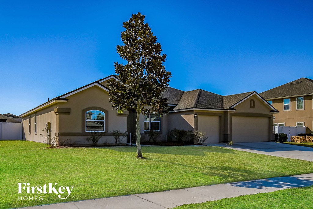 a house with a lawn and a tree in front of it