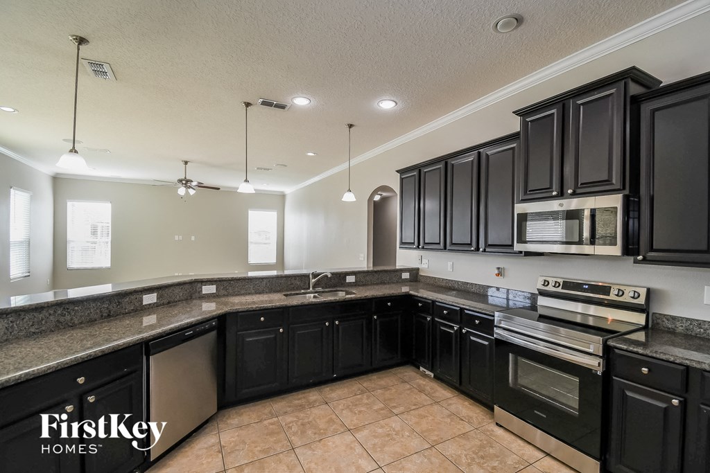 a kitchen with black cabinets and granite counter tops