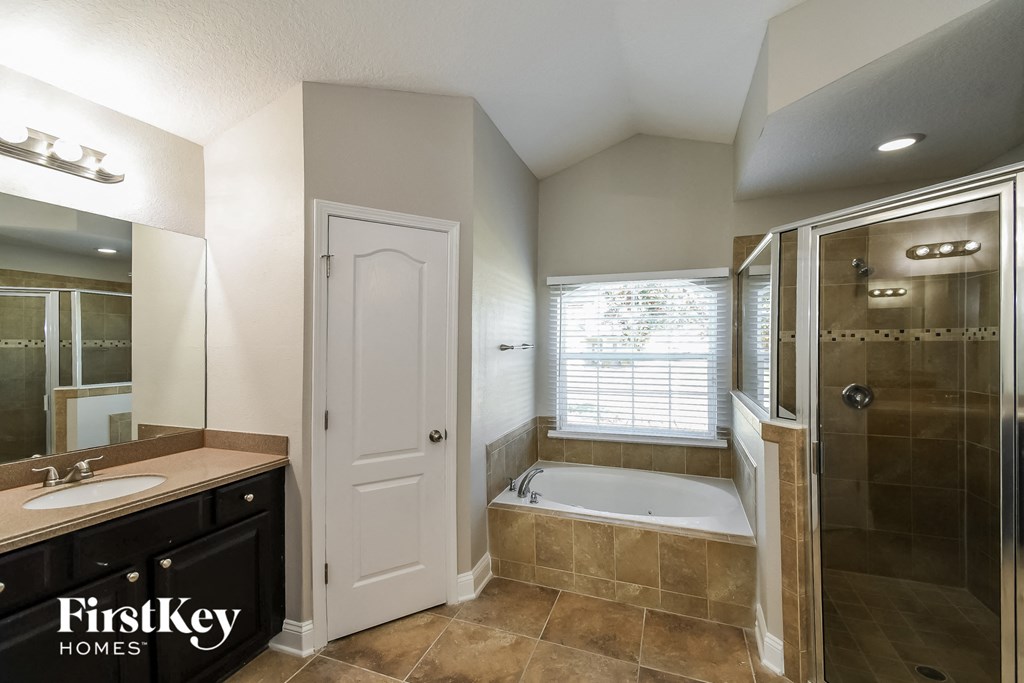a bathroom with a tub and a shower and a sink