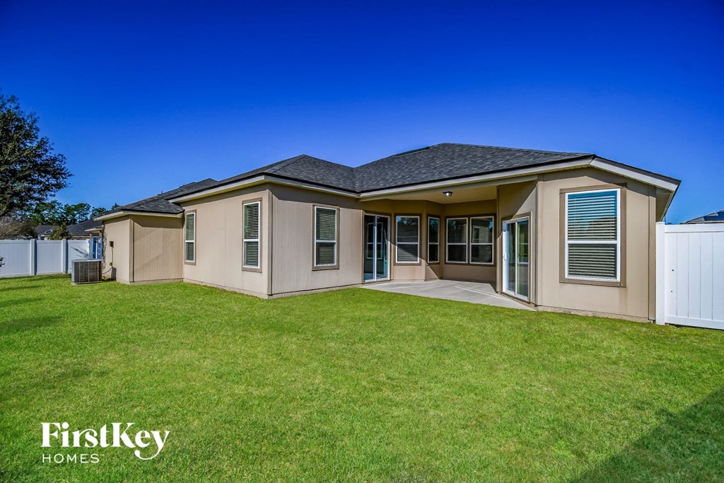 a beige house with a yard and grass