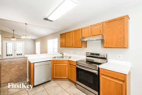 a kitchen with wood cabinets and black appliances and white counter tops