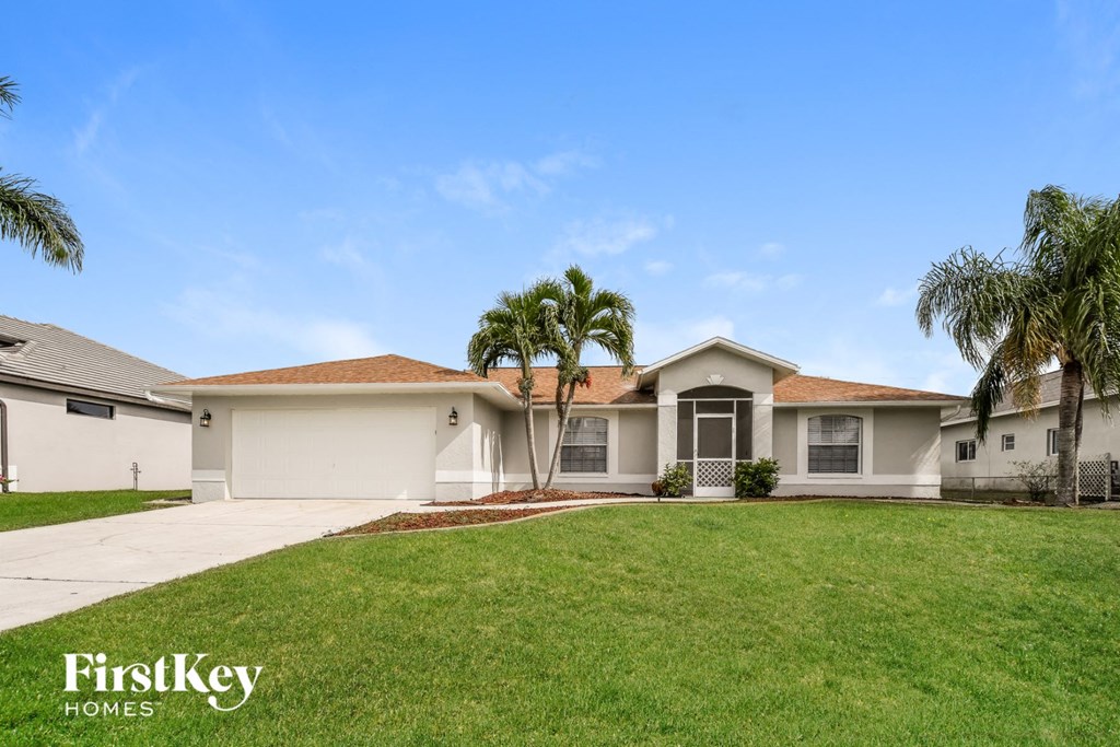 a house with palm trees in front of it and a lawn