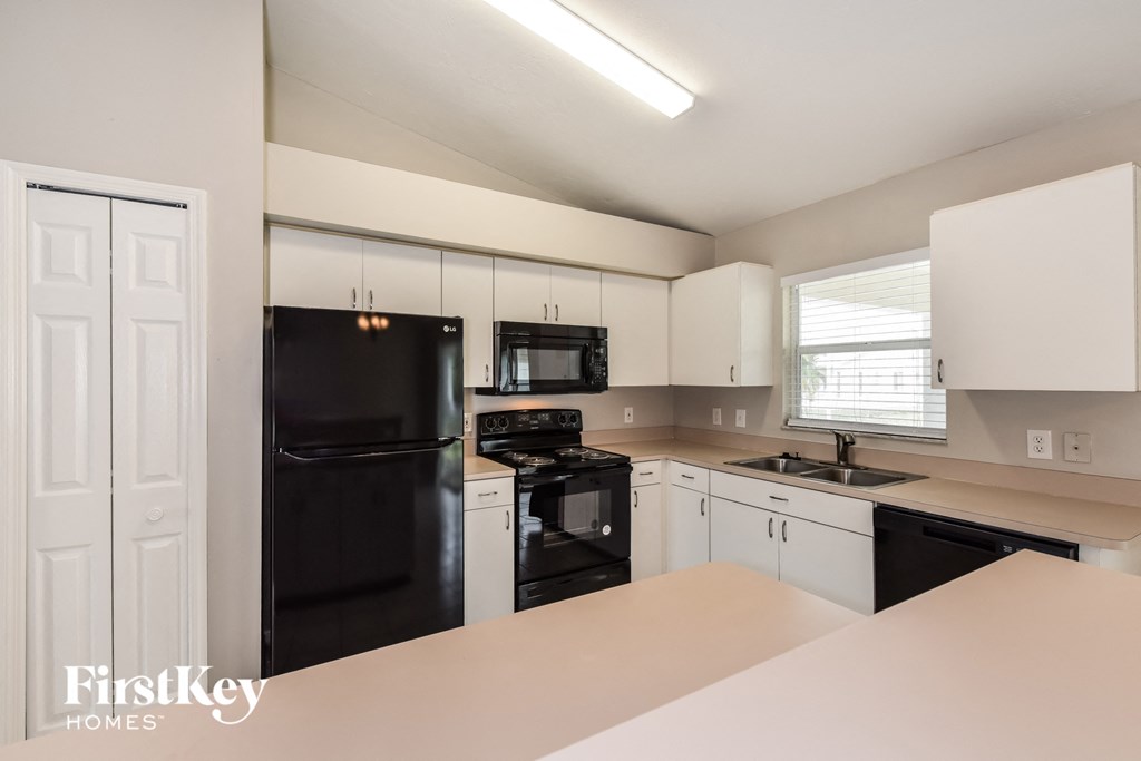 a kitchen with black appliances and white cabinets